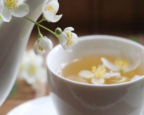 A soothing cup of herbal tea surrounded by fresh lavender on a wooden desk